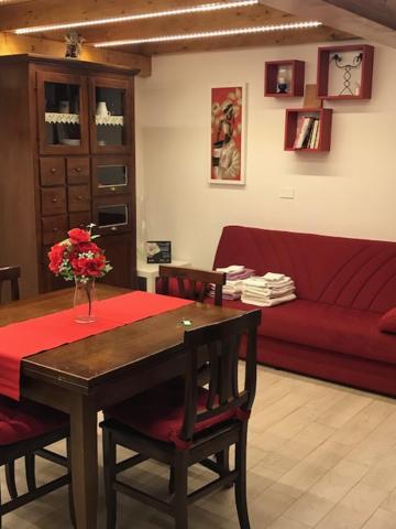 阿尔巴诺拉齐亚莱阿尔巴诺度假公寓的客厅配有桌子和红色沙发