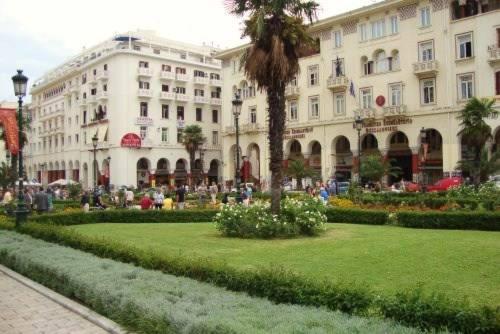 塞萨洛尼基Aristotelous Square Luxury Apartment的前面有绿色草坪的大建筑