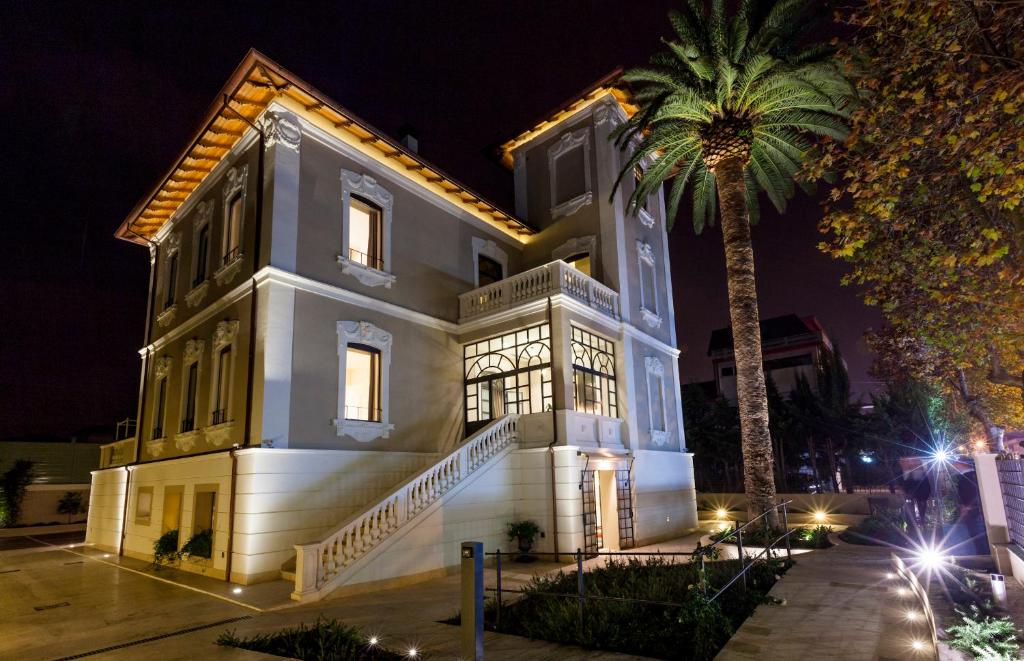 朱利亚诺瓦900酒店的一间在晚上种植棕榈树的大型白色房子