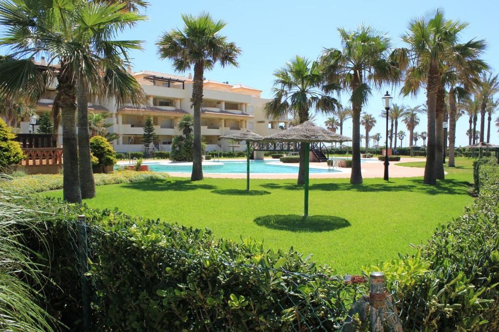 滨海罗克塔斯Villa Romana Roquetas的棕榈树公园和游泳池的度假村