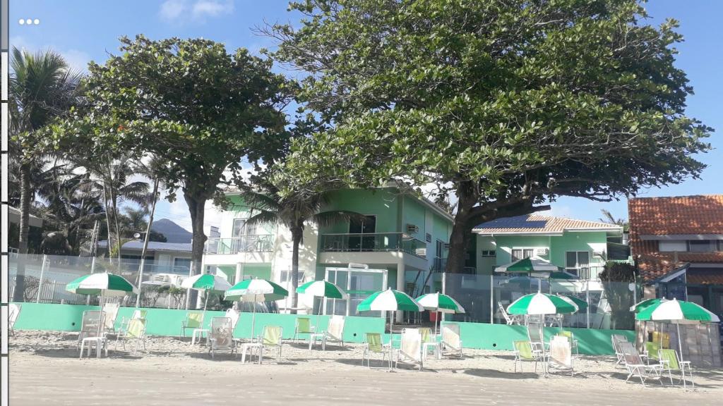 贝卢港Pousada Vila Verde的一组椅子和遮阳伞在建筑前