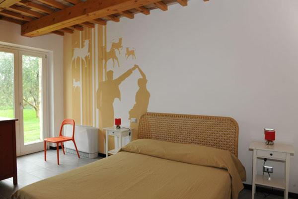 洛雷托Casale Papa Country Village的一间卧室配有一张床,墙上挂着一幅画画
