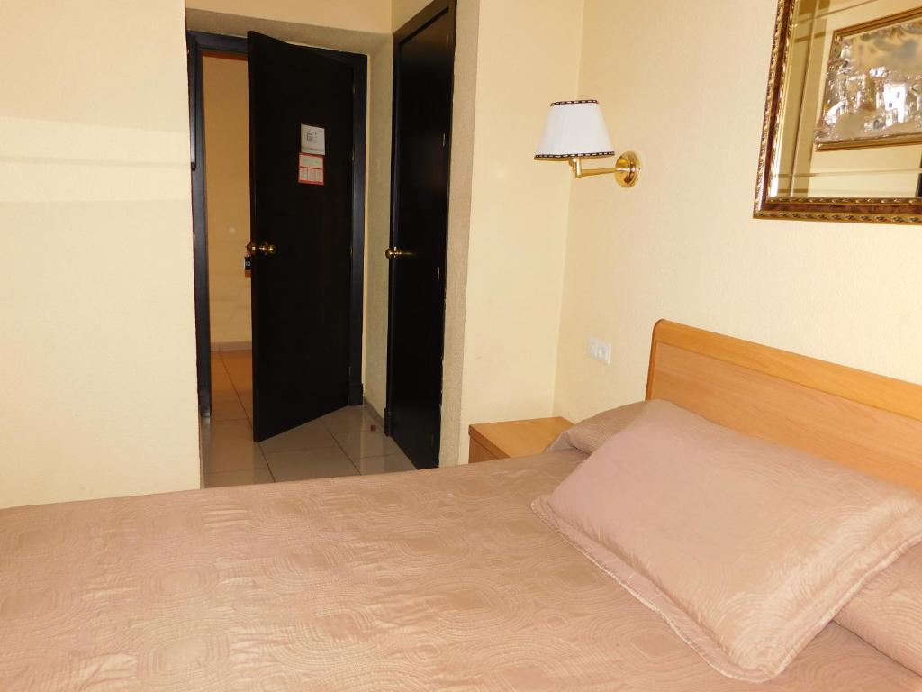 圣费尔南多罗马酒店 的一间卧室配有一张床、镜子和门