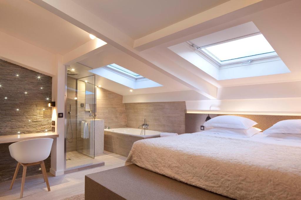 巴黎Georgette Hôtel & Restaurant的一间卧室设有一张大床和一个浴缸