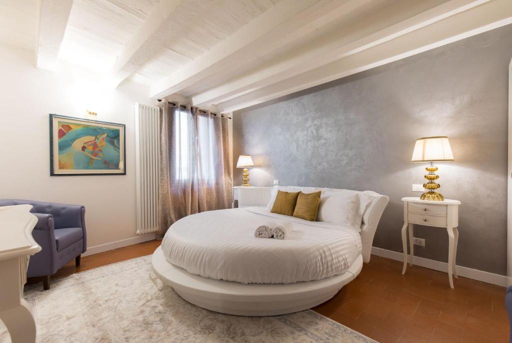 维琴察Residenza Vescovado的卧室配有白色的床和蓝色的沙发
