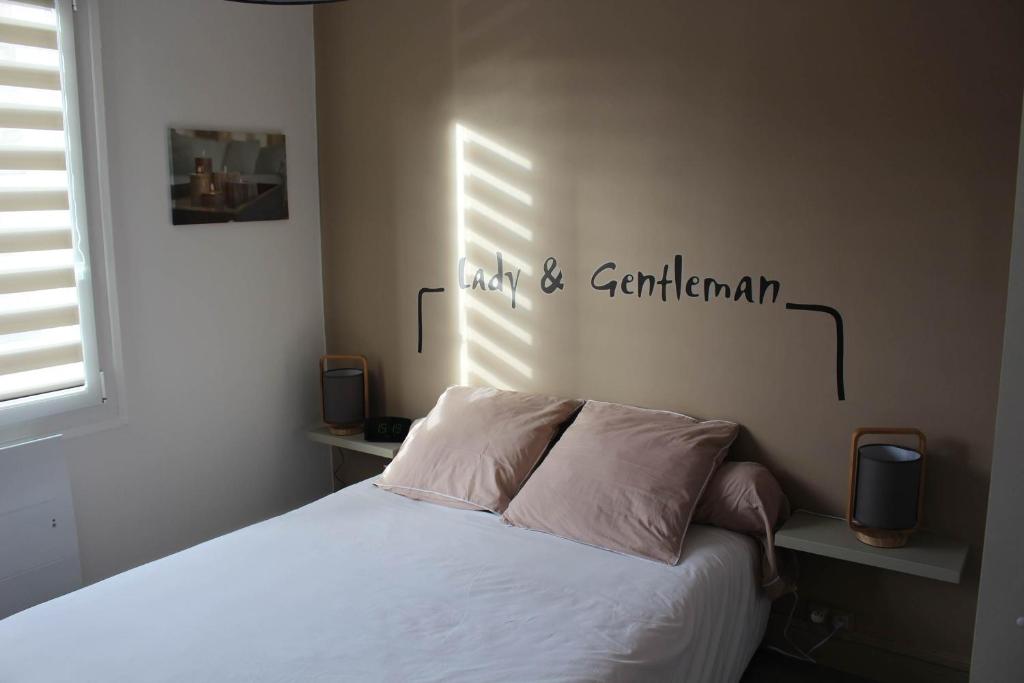 迪耶普Appartement Quai Ouest的卧室配有一张床,墙上有标志