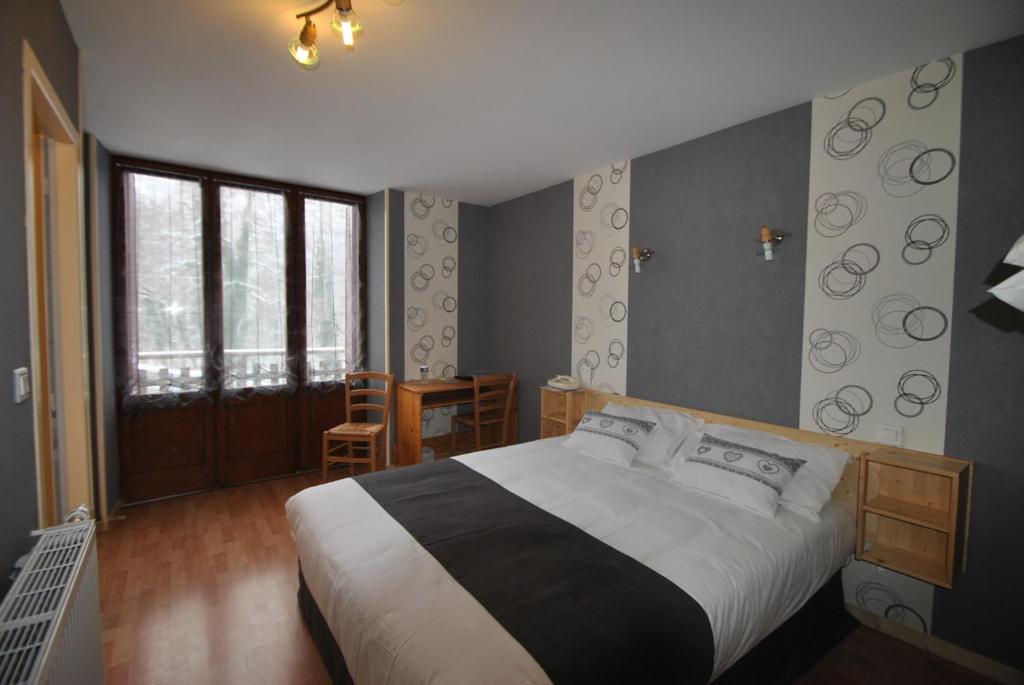 La Chaux-du-Dombief埃里松旅馆的一间卧室配有一张大床和一张桌子及椅子