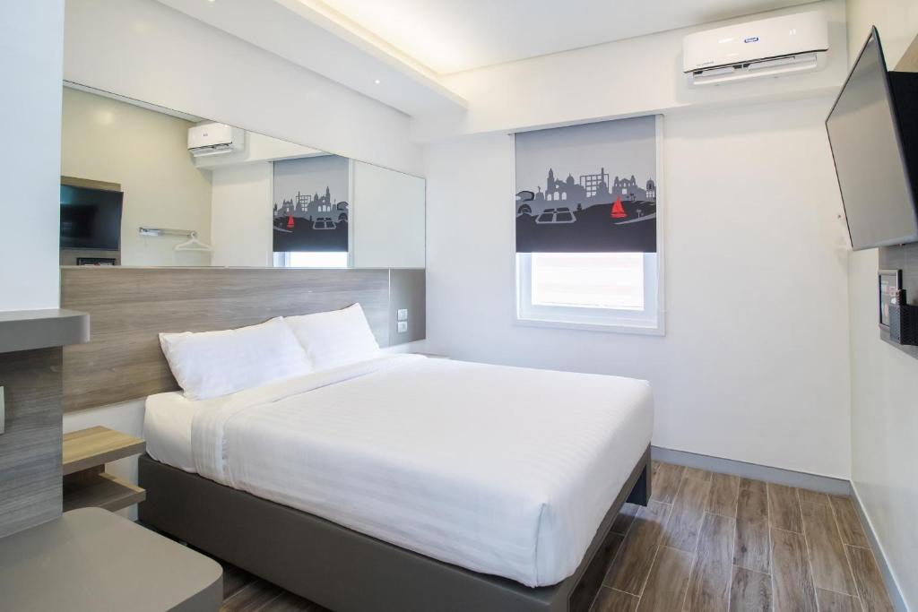 马尼拉Red Planet Manila Bay的卧室配有一张白色大床