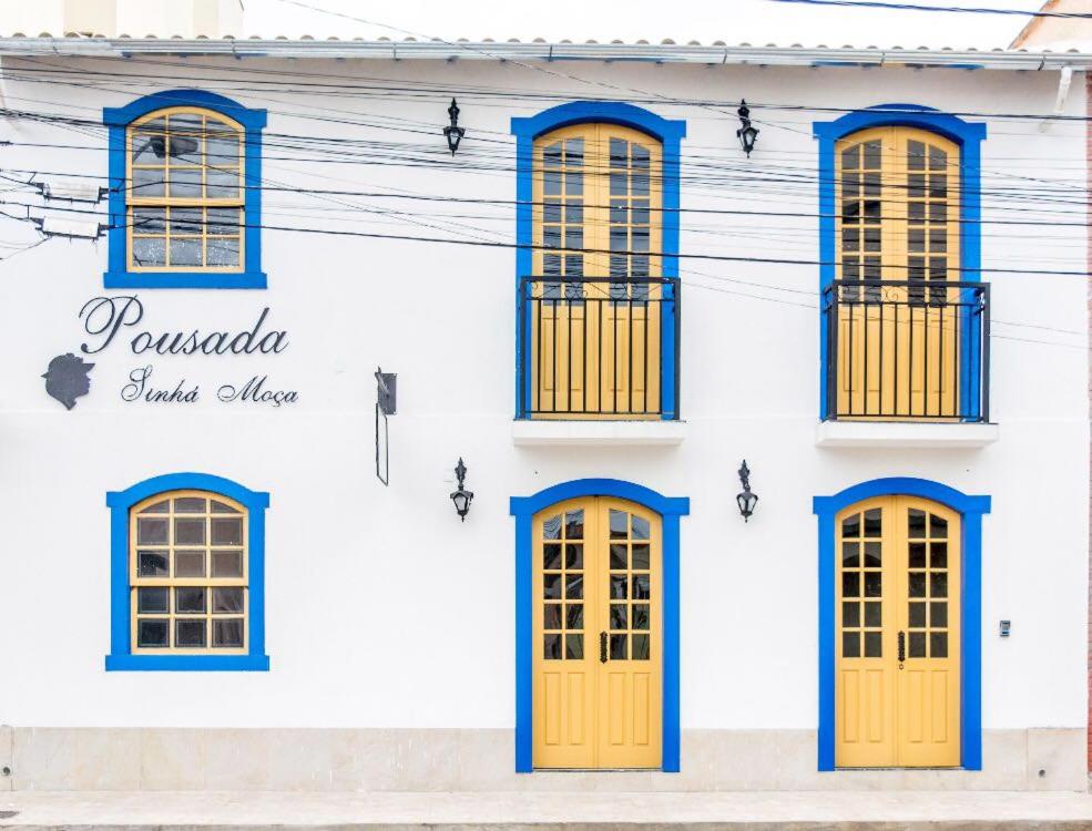 圣若昂-德雷Pousada Sinhá Moça的白色的建筑,设有黄色的门窗