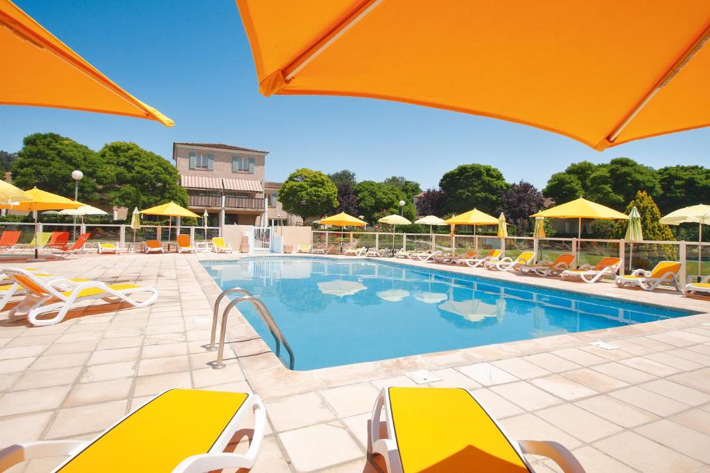 蒙托鲁Le Champ d'Eysson Aparthotel的一个带椅子和遮阳伞的游泳池