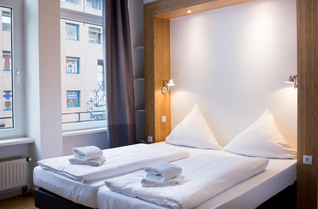 科布伦茨叮当科布伦茨城市公寓式酒店的酒店客房设有两张床和窗户。