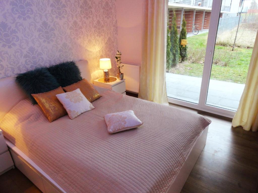 弗罗茨瓦夫Na Grobli 014的卧室配有带枕头的床铺和窗户。