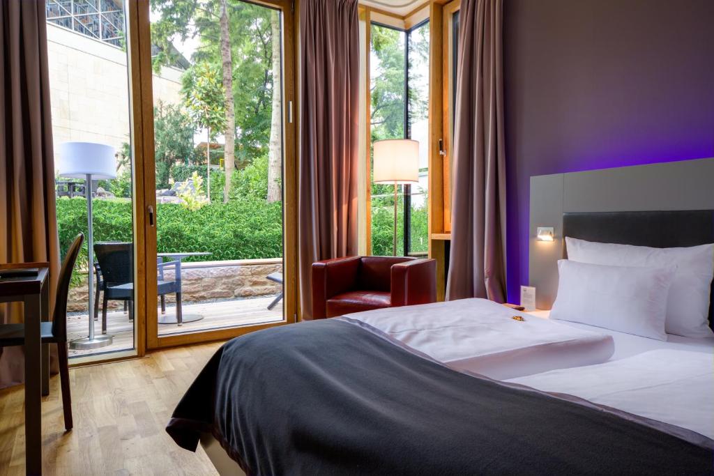 海德堡Qube Hotel Bergheim的酒店客房设有一张床和一个大窗户