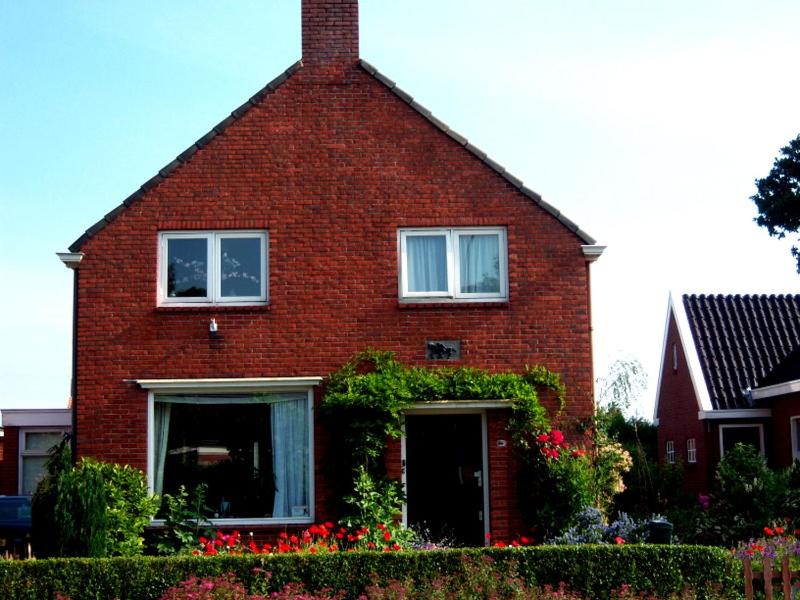 Warffumde Twee Paardjes的前面有鲜花的红砖房子