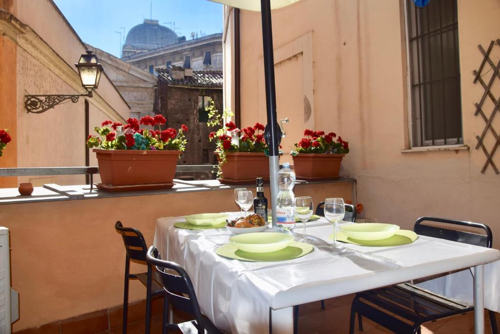 罗马库尔罗马公寓的阳台上的一张桌子和白色的桌布
