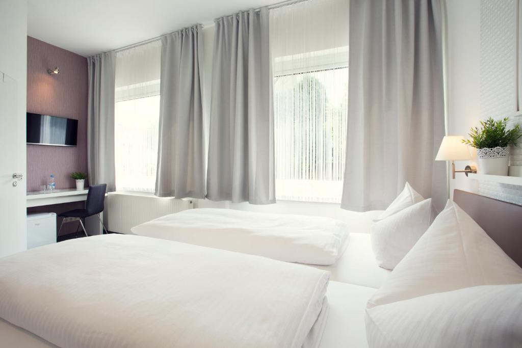 蒙塔鲍尔莱恩古斯酒店的酒店客房配有两张床和一张书桌