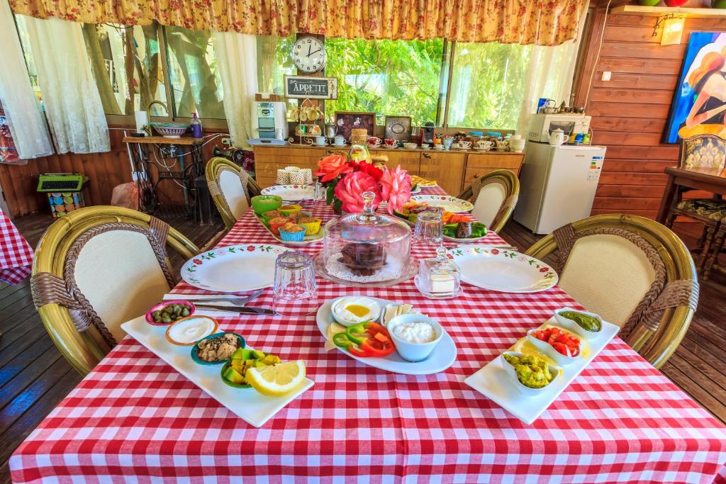 KahalBetzel Ha'Ella的一张桌子,上面有红色的格子布,上面有食物