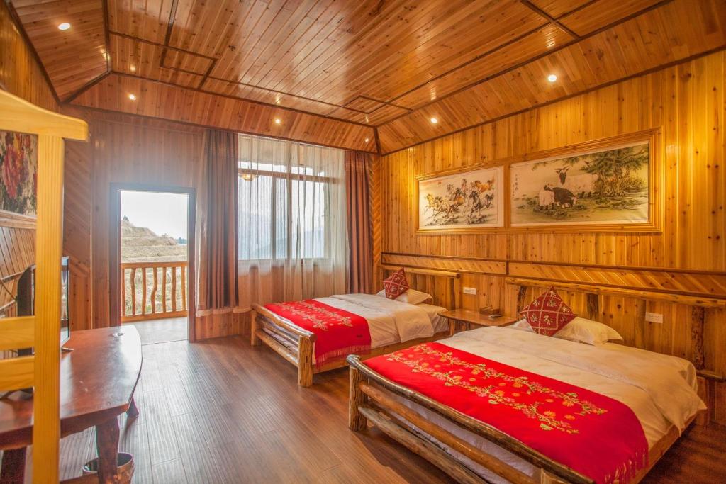 龙胜龙安酒店的配有木墙和木地板的客房中的两张床