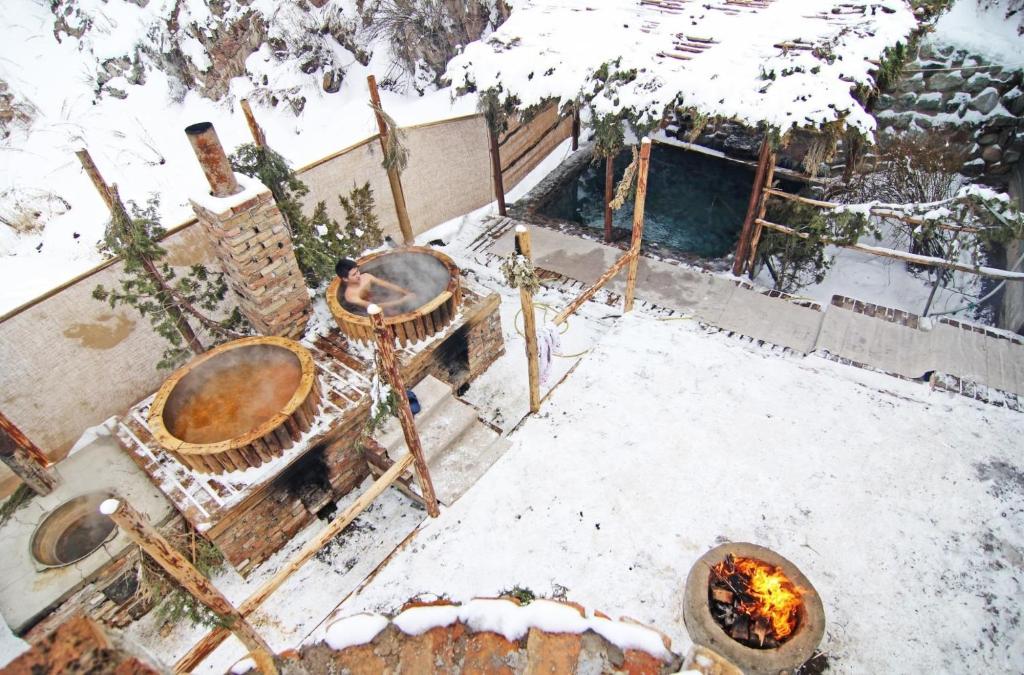 Alamedin卡拉布拉克生态度假酒店的积雪覆盖的院子,有火坑和雪