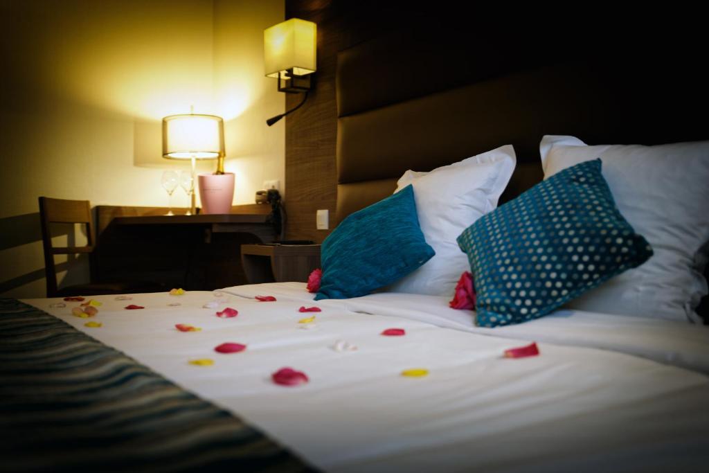 马图格国际之家奥贝奇莫森的一张带鲜花的床,上面有台灯和桌子