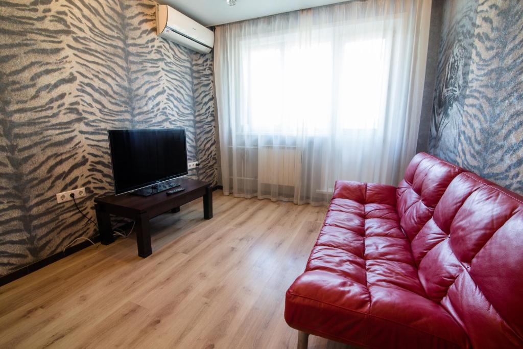 新库兹涅茨克Apartments on Kirova 76的客厅配有红色沙发和电视