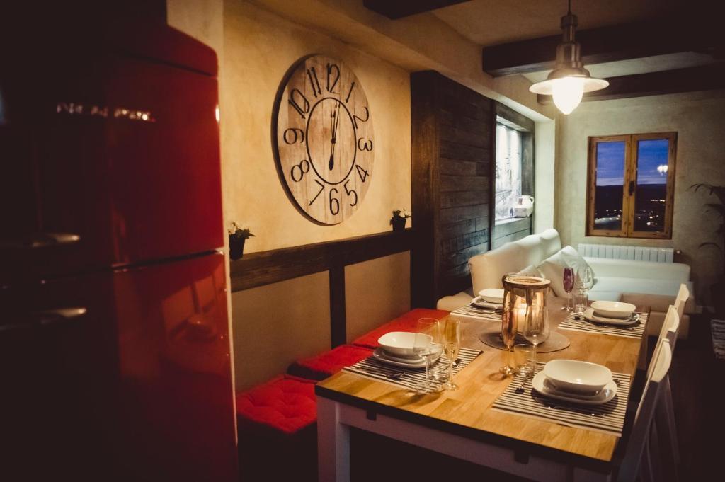 昆卡Luxury Danna Plaza Mayor的厨房配有一张桌子,墙上挂着一个时钟