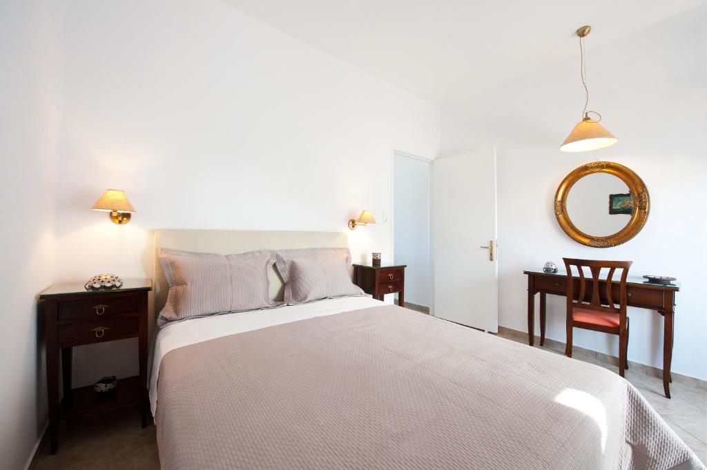 阿达玛斯Tsakanos Apartments的一间卧室配有一张床、一张书桌和一面镜子