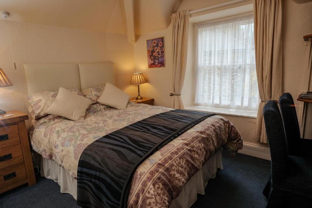 多尔盖罗常春藤旅馆的一间卧室设有一张大床和一个窗户。