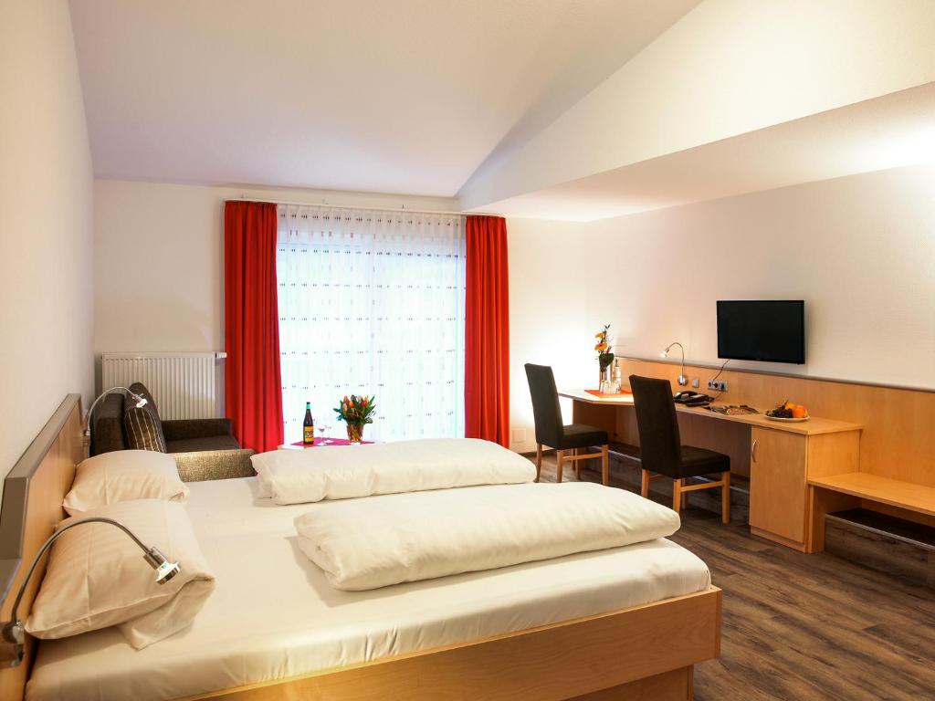 MottenHotel Gasthof zum Biber的酒店客房设有两张床和一张带电脑的书桌