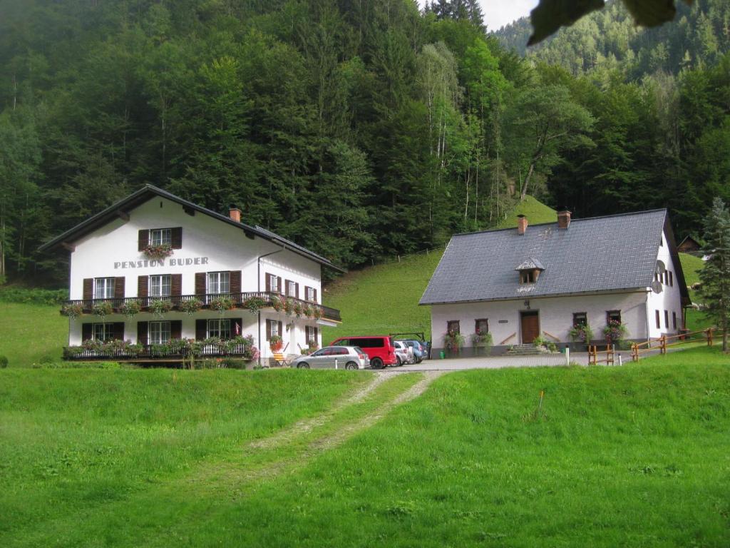 LassingFerienhaus Mendlingbauer的一座白色的大建筑,汽车停在田野里