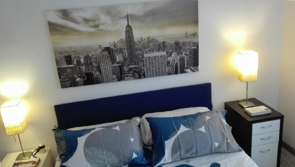 米兰米兰M3地铁站附近的漂亮公寓的卧室配有蓝色的床,墙上挂着一幅画