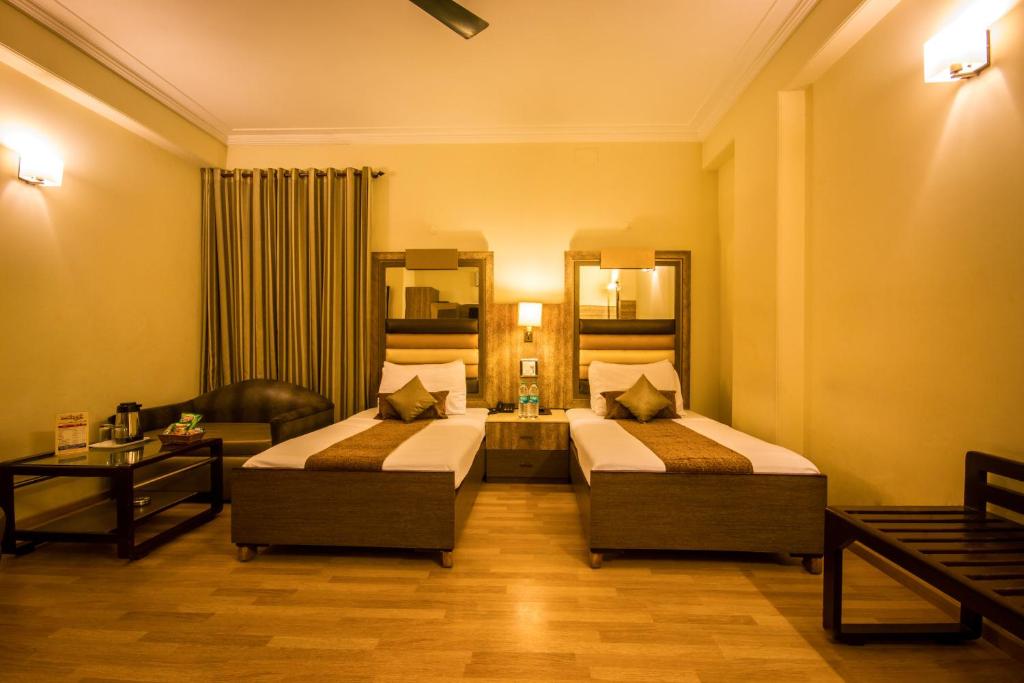 新德里雅翠桑科特酒店的酒店客房,设有两张床和一张沙发