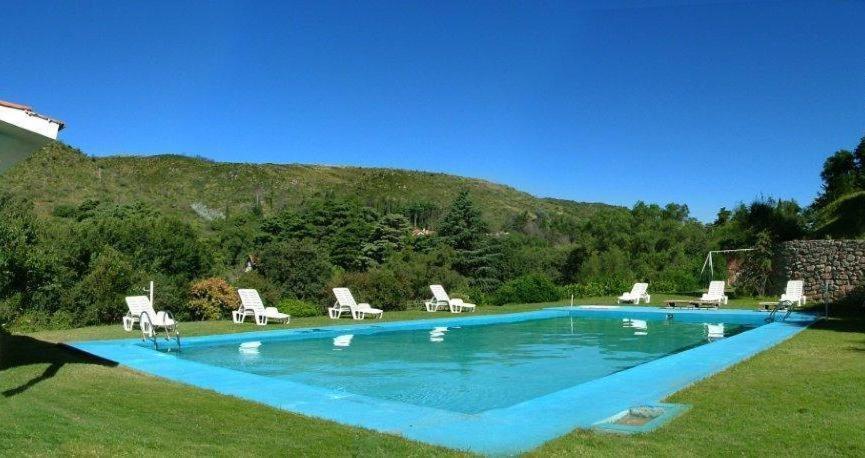 拉库布蕾Gran Hotel La Cumbre的一个带椅子的蓝色游泳池和山脉