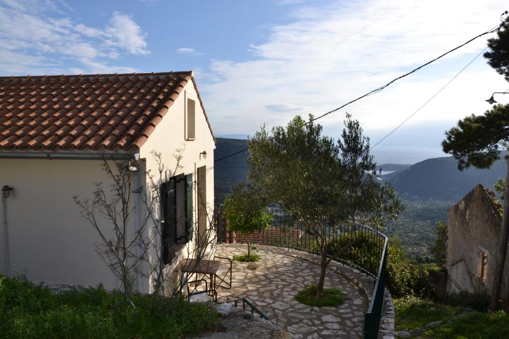 ExoyíFassoulou's cottage的山丘上带桌椅的白色房屋