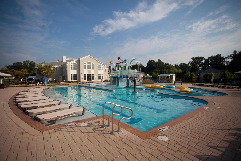 威廉斯堡威廉斯堡殖民地酒店的一个带椅子的大型游泳池,一个度假村