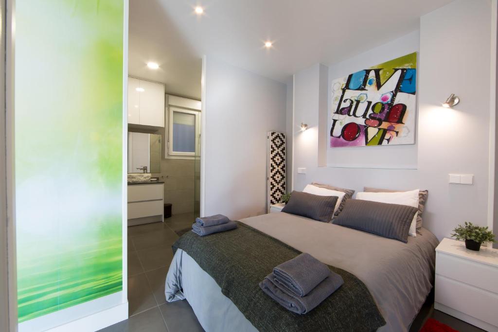 马德里WindRose 2的卧室配有一张床,墙上挂有绘画作品