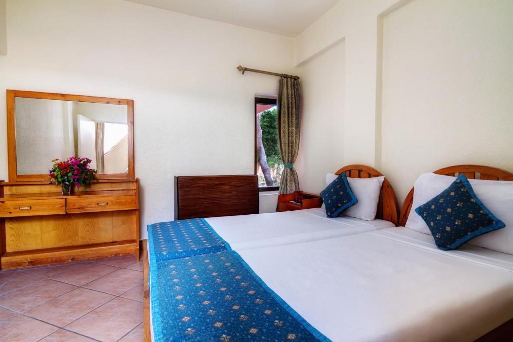 赫尔格达Eagles Paradise Abu Soma Resort的一间卧室配有两张床、镜子和梳妆台