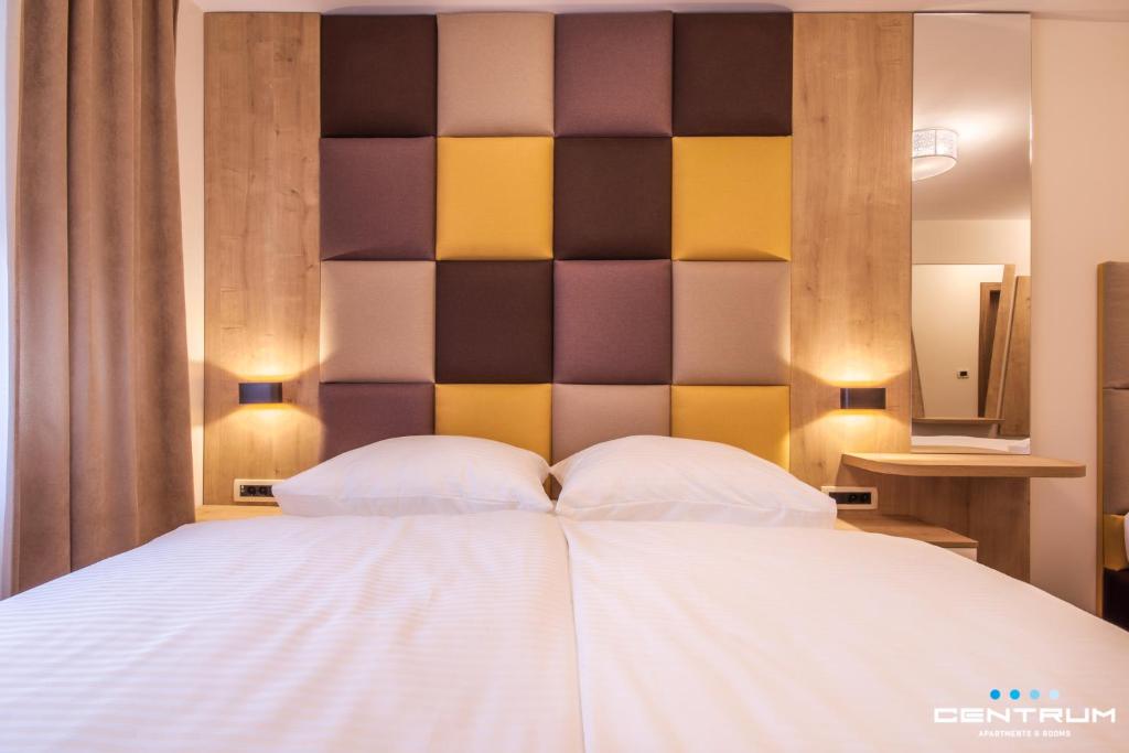 奥西耶克Centrum Osijek的一间卧室配有一张大床和大床头板