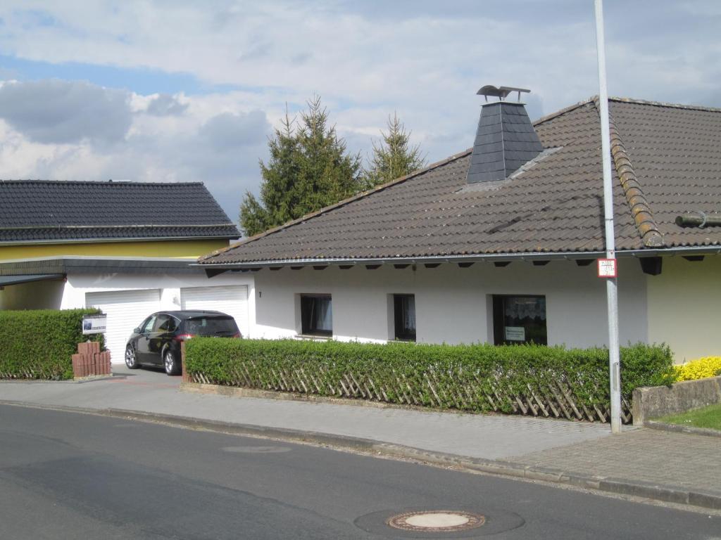 梅谢尼希Haus Alexander的白色的房子,有黑色的屋顶和汽车
