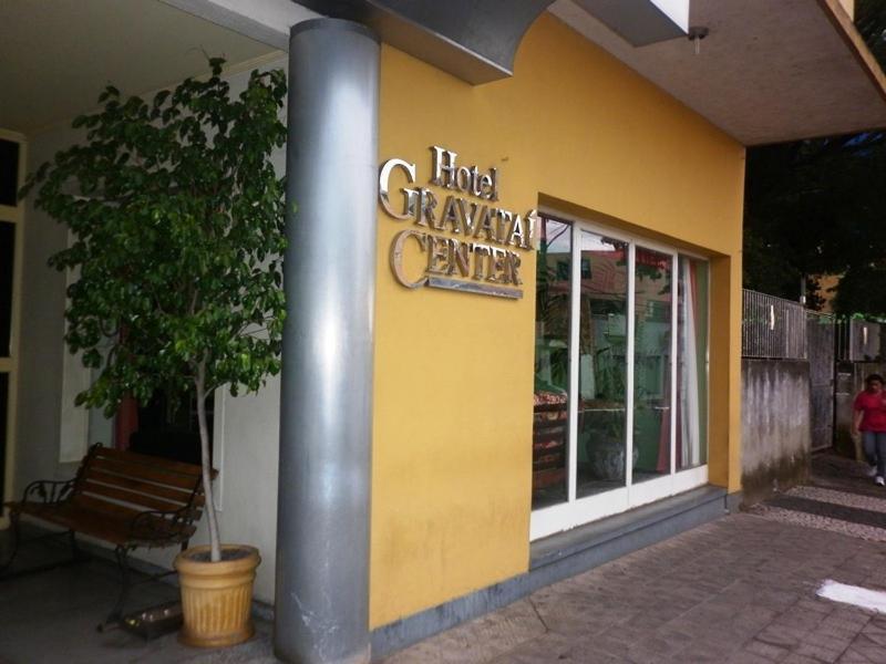 格拉瓦塔伊格拉瓦塔伊中心酒店的带有环形车库中心标志的黄色建筑