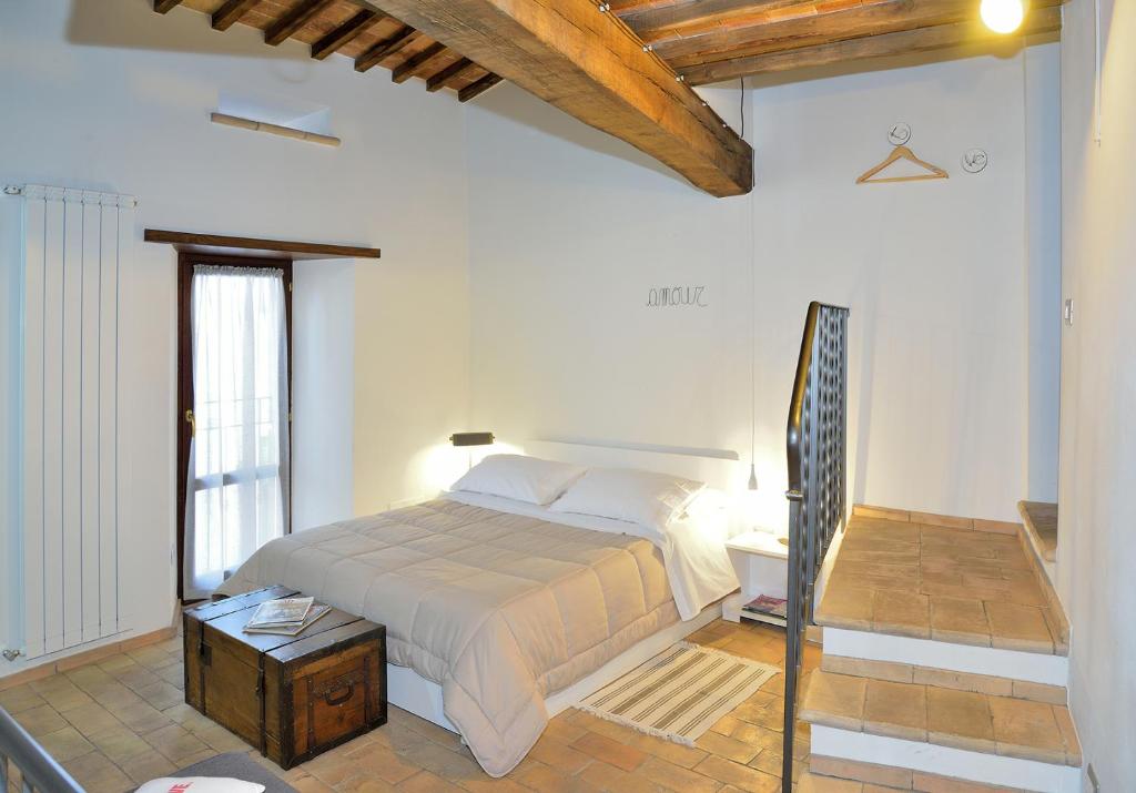 巴尼奥雷焦裴傲尼亚农家乐的一间白色客房内的床铺卧室