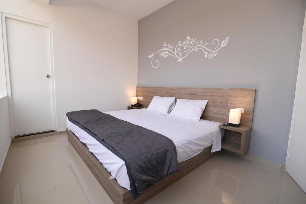 齐克拉约Hotel Escala的一间卧室配有一张带白色床单的大床