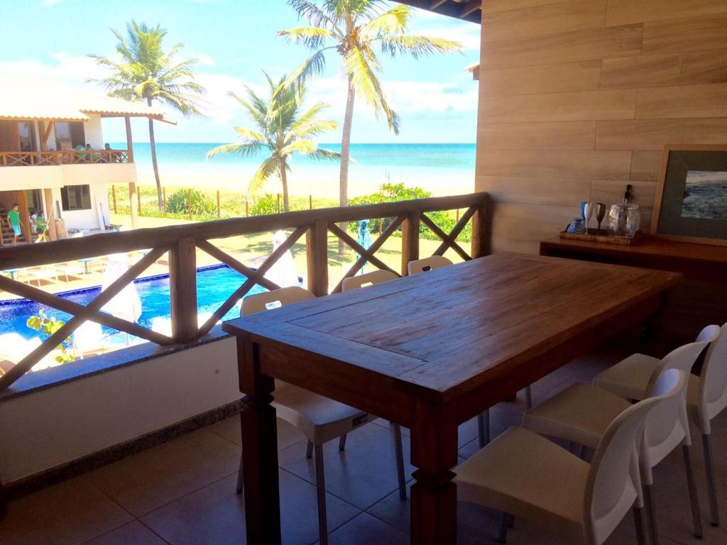 伊塔齐米林Village Beira Mar em Itacimirim的一间设有桌子的海景用餐室