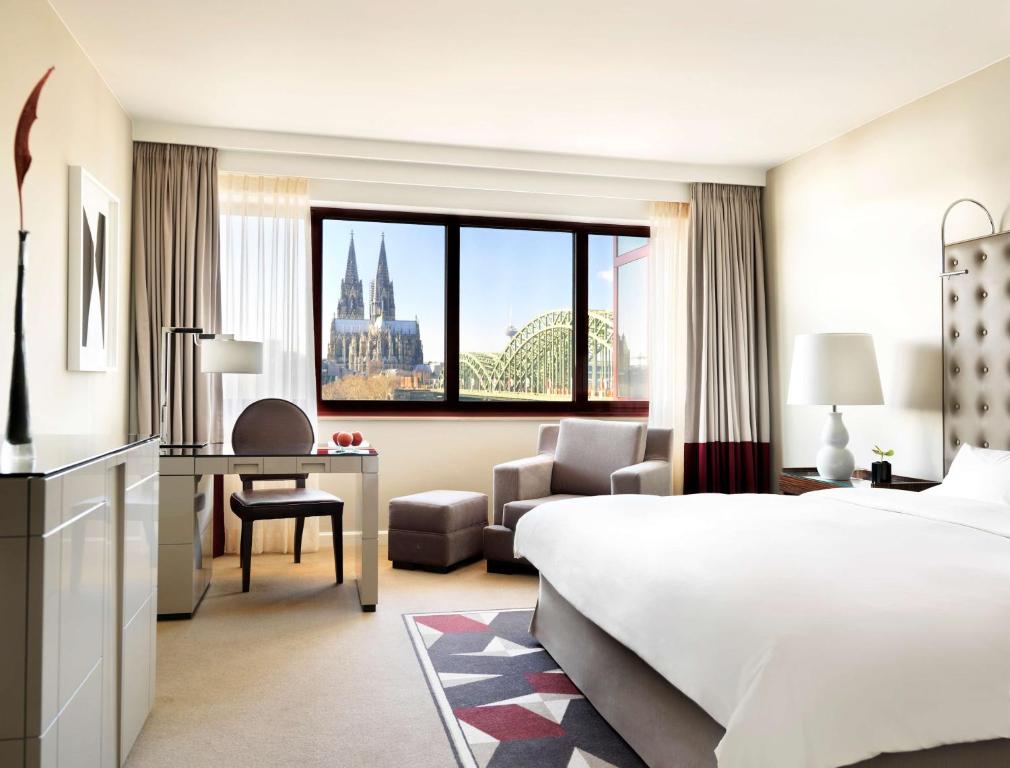 科隆科隆凯悦酒店的酒店客房带一张床铺、一张书桌和一间卧室