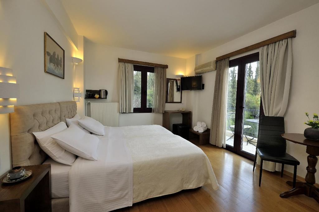 雅典德莱尔德斯猎户座酒店的卧室配有一张白色的大床和一张沙发。