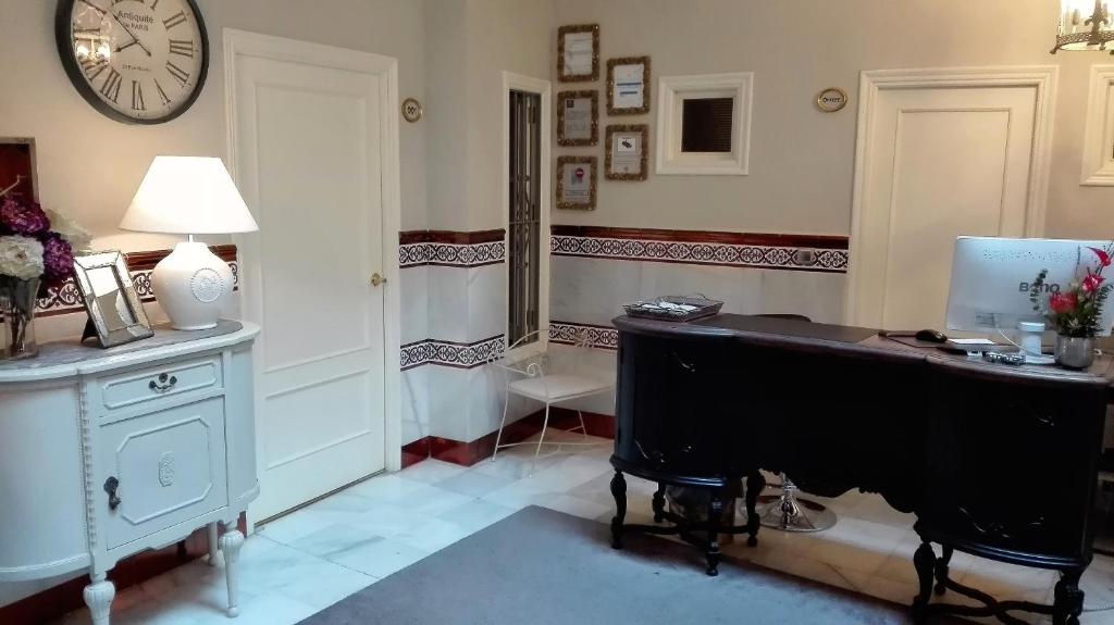 塞维利亚巴黎乐派酒店的配有书桌、电脑和时钟的房间
