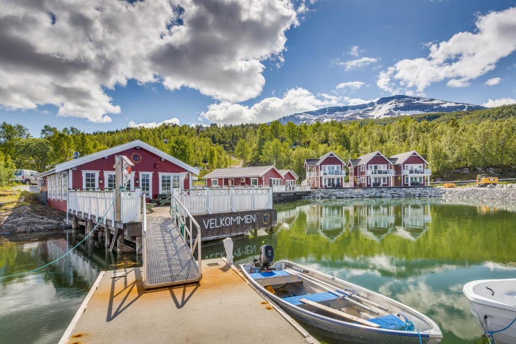Sjøvegan贾斯尼布里格度假屋的水面上带船的码头,有房子