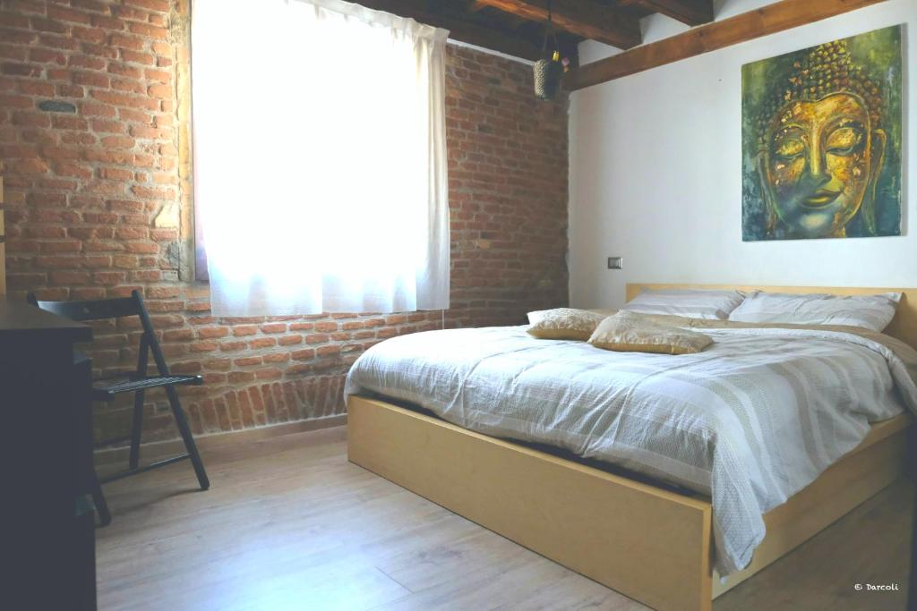 维琴察Vivi Vicenza的一间卧室设有一张带砖墙的大床