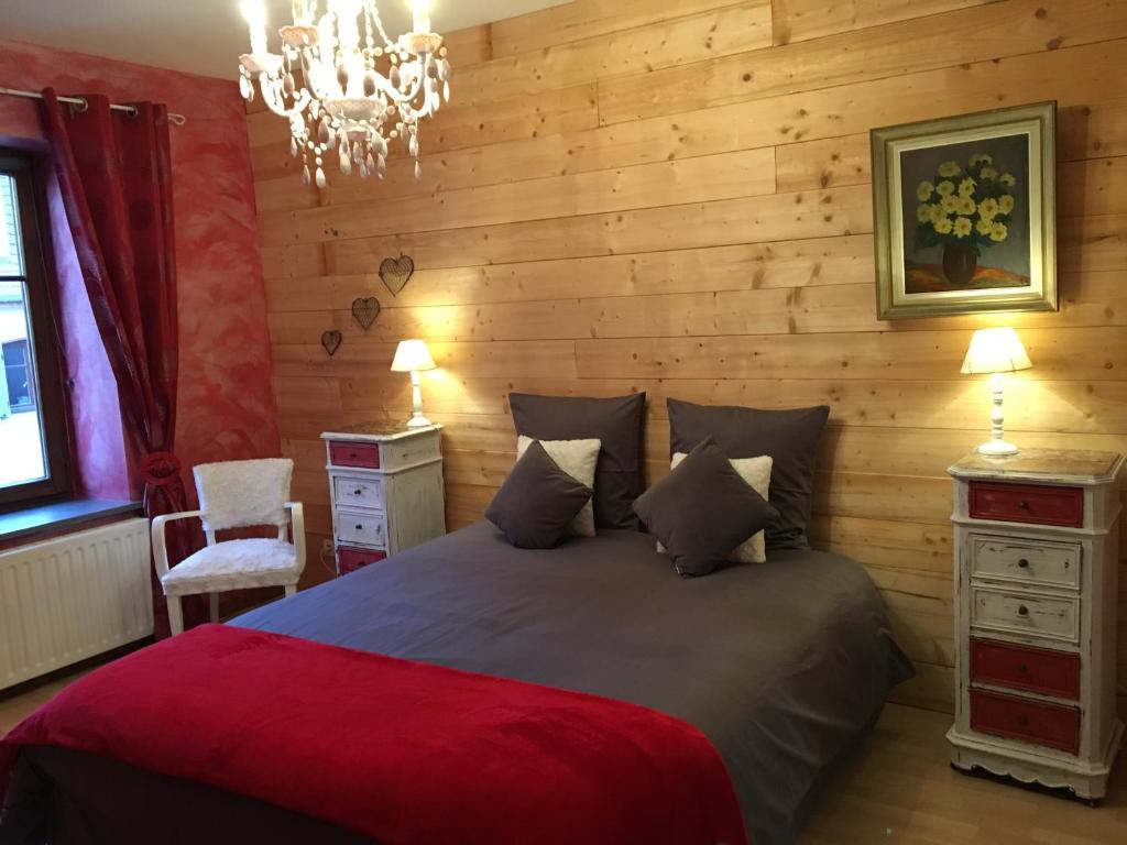 拉佩蒂特皮耶尔Les appartements d'estelle的一间卧室设有一张带木墙的大床