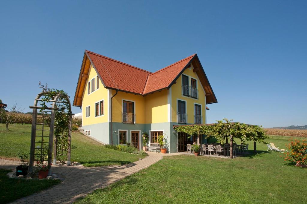 GroßkleinWeingut Winzerhof Gästezimmer Grebenz的红色屋顶的大型黄色房屋